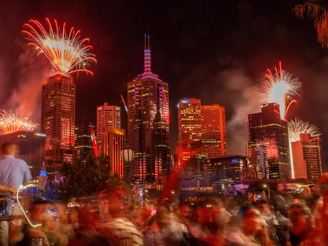 Revellers watch the fireworks in the Melbourne CBD. Picture: Mark Stewart