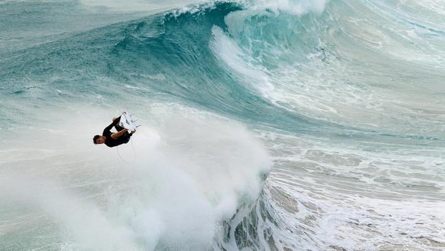 A surfer is seen at Duranbah, the northernmost beach in New South Wales, Thursday February 21, 2019. Huge swells and high tides are set to pummelling south-east Queensland and far-northern New South Wales beaches over the coming days as Cyclone Oma tracks towards the Queensland coast. (AAP Image/Dave Hunt)