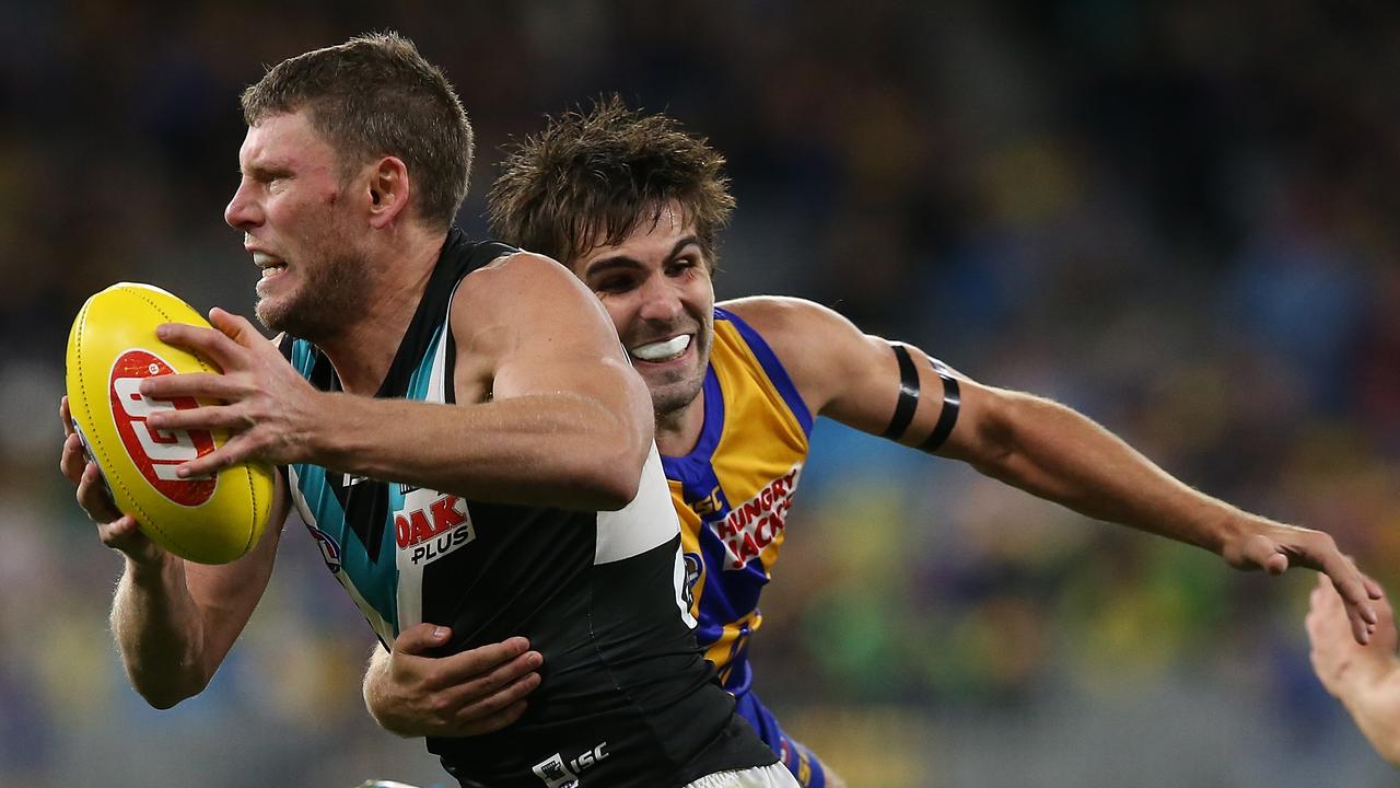 Brad Ebert of the Power breaks from a tackle by Andrew Gaff of the Eagles. Picture: Paul Kane/Getty Images