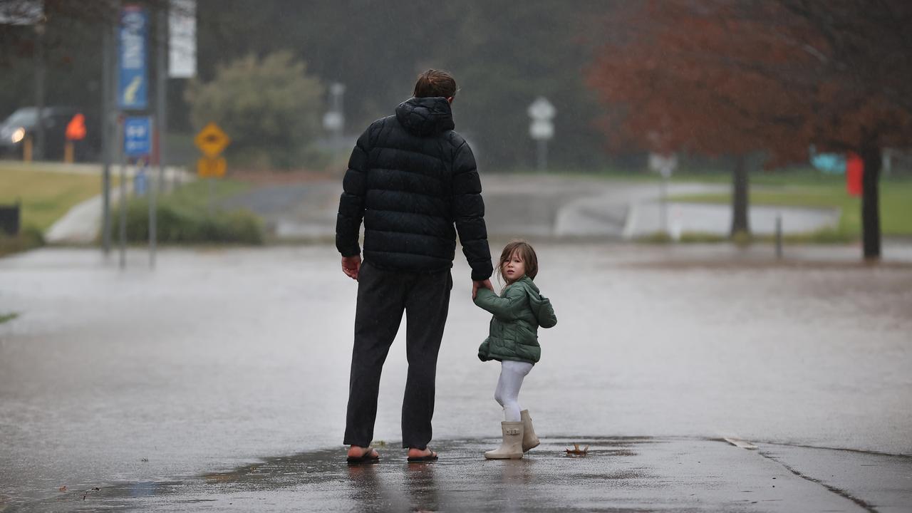 Derek Harman and daughter Charlotte 3, look at floodwater in Sale from Flooding Creek over Canal Rd. Picture: David Caird