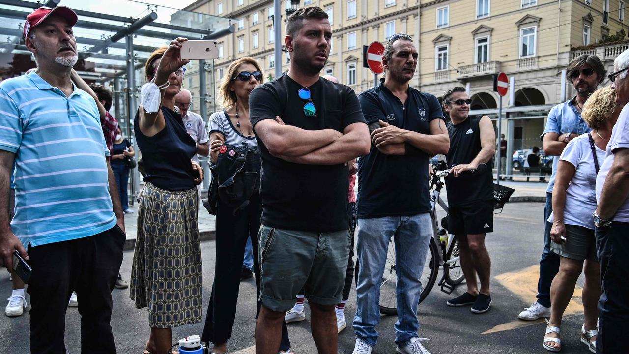 But not all are happy. People hold a silent protest against the so-called Green Pass vaccination passport outside the Porta Nuova railway. Picture: Marco Bertorello / AFP