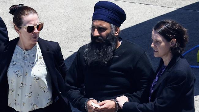 Queensland Police escort Rajwinder Singh from a chartered jet to a waiting police car at Cairns Airport. He allegedly left Australia for India the day after Toyah Cordingley’s body was found at Wangetti Beach. Picture: Brendan Radke