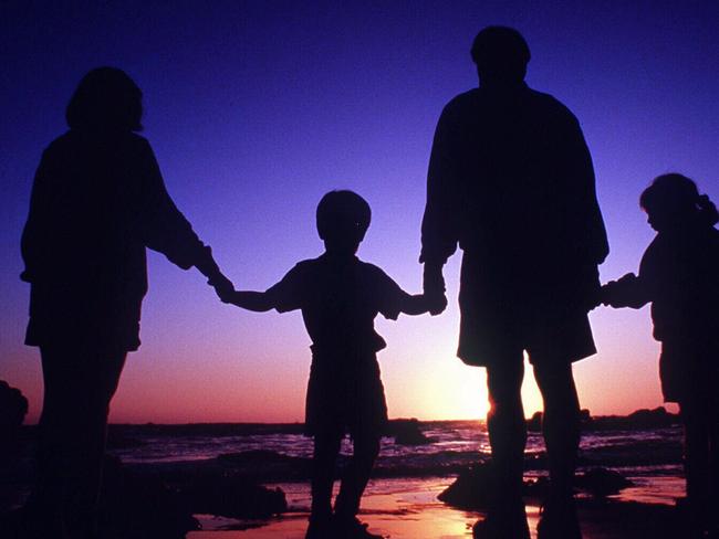 Undated. Silhouette of a generic family with parents and children holding hands. Beach. Sunset. People.