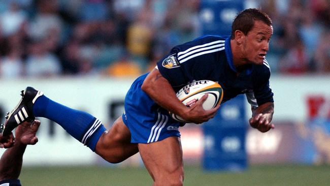 the Blues Carlos Spencer is tackled by the brumbies Radike Samo, in the Canberra Brumbies VS the Auckland Blues, At Canberra Stadium. pic kym smith 21/02/04