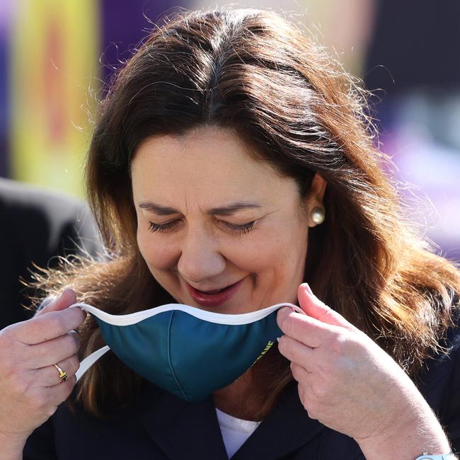 Queensland Premier Annastacia Palaszczuk putting on a face mask. Picture: Peter Wallis