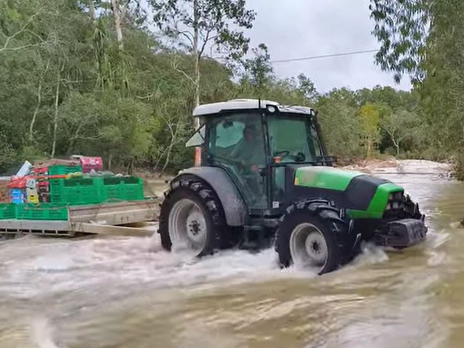 Farmer crosses flood water in tractor to deliver fruits, vegetables