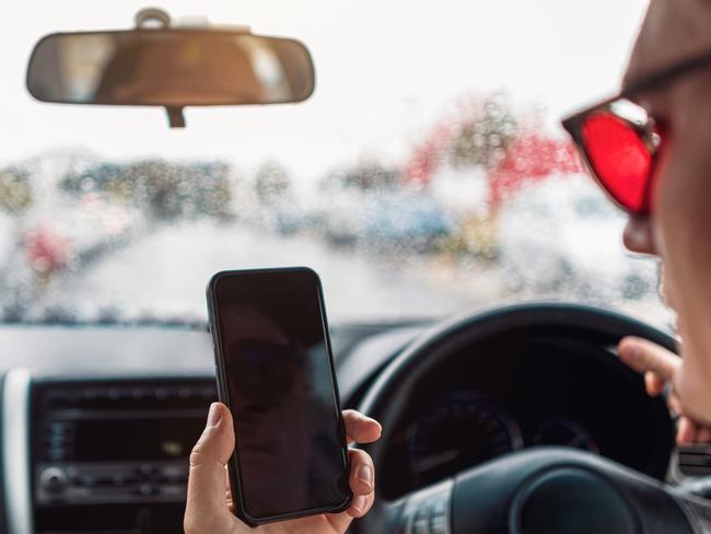 Distracted Driver Talking On Mobile Phone On Rainy Urban Street