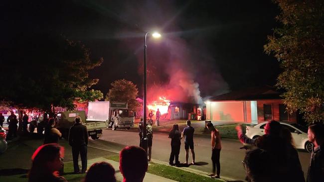 Neighbours gather outside the burned house. Picture: Facebook