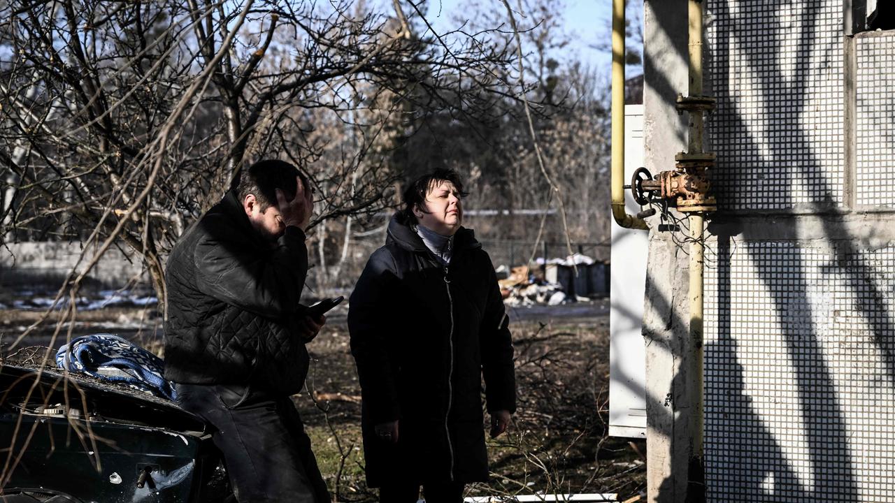 People react outside a destroyed building after bombings in Chuguiv. Russsia's ground forces on Thursday crossed into Ukraine from several directions. Picture: Aris Messinis / AFP