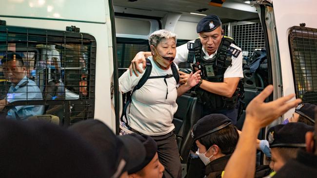 Police remove a woman from a gathering held to commemorate the victims on this year’s anniversary of the massacre. Picture: Getty