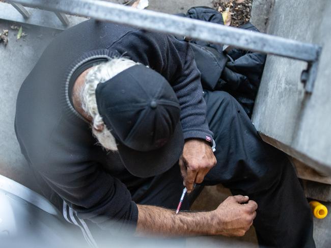 A man is seen injecting in a carpark next to North Richmond Community Health, which houses the medically supervised injecting room. Picture: Sarah Matray