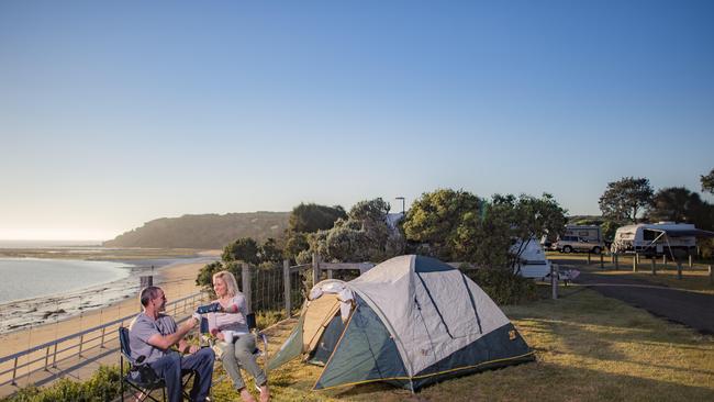 Couple Glen Ryan and Lauren Harsley enjoy sunrise from one of the caravan sites at Barwon Heads. Picture: Jason Edwards