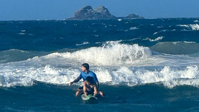 Five-time Coolangatta Gold ironman champion and Guinness World Record pull-up holder Caine Eckstein rescuing an English couple in choppy water at Main Beach, Byron Bay. Picture: Supplied