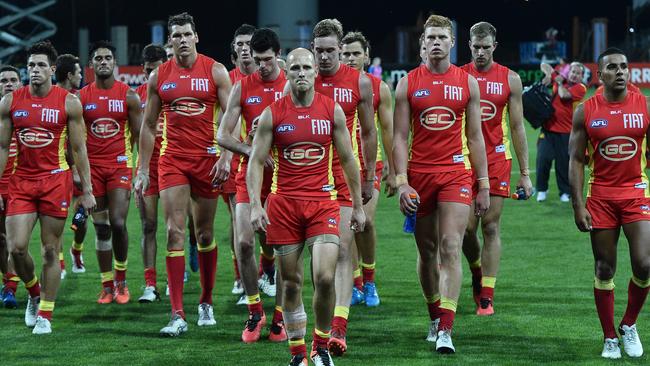 Gary Ablett leads the dejected Suns off the field after their massive loss to Geelong. Picture: AAP