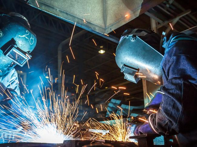 The movement of workers with protective mask welding metal. Australian manufacturing workers generic, blue collar