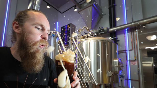 Head Brewer Ryan Fullerton blows the froth off a new brew. Picture: Glenn Hampson.