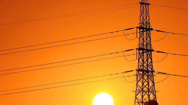 The sun sets behind powerlines in the west of Melbourne, Victoria. *power, electricity, energy* Picture: Mark Stewart