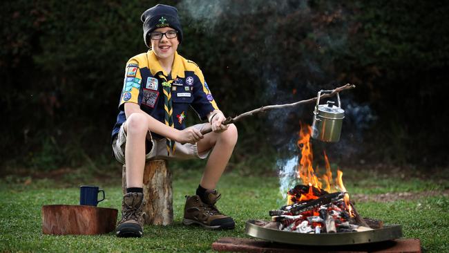 Colbalt Walsh, 10, heats up his billy over an open fire he made while camping in his backyard during lockdown. Picture: Richard Dobson