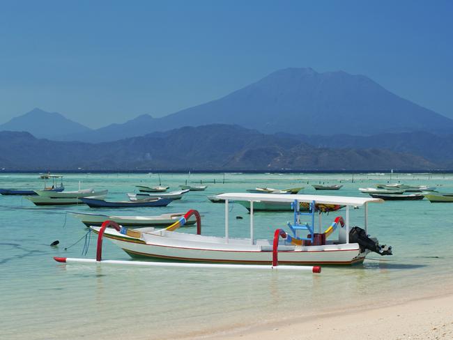 Boats along the coast of the island of Nusa Lembongan, with Bali's Mt Agung in the distance. Indonesia.CREDIT: Getty Imagesescape29 august 2021my travel CV melissa tapper