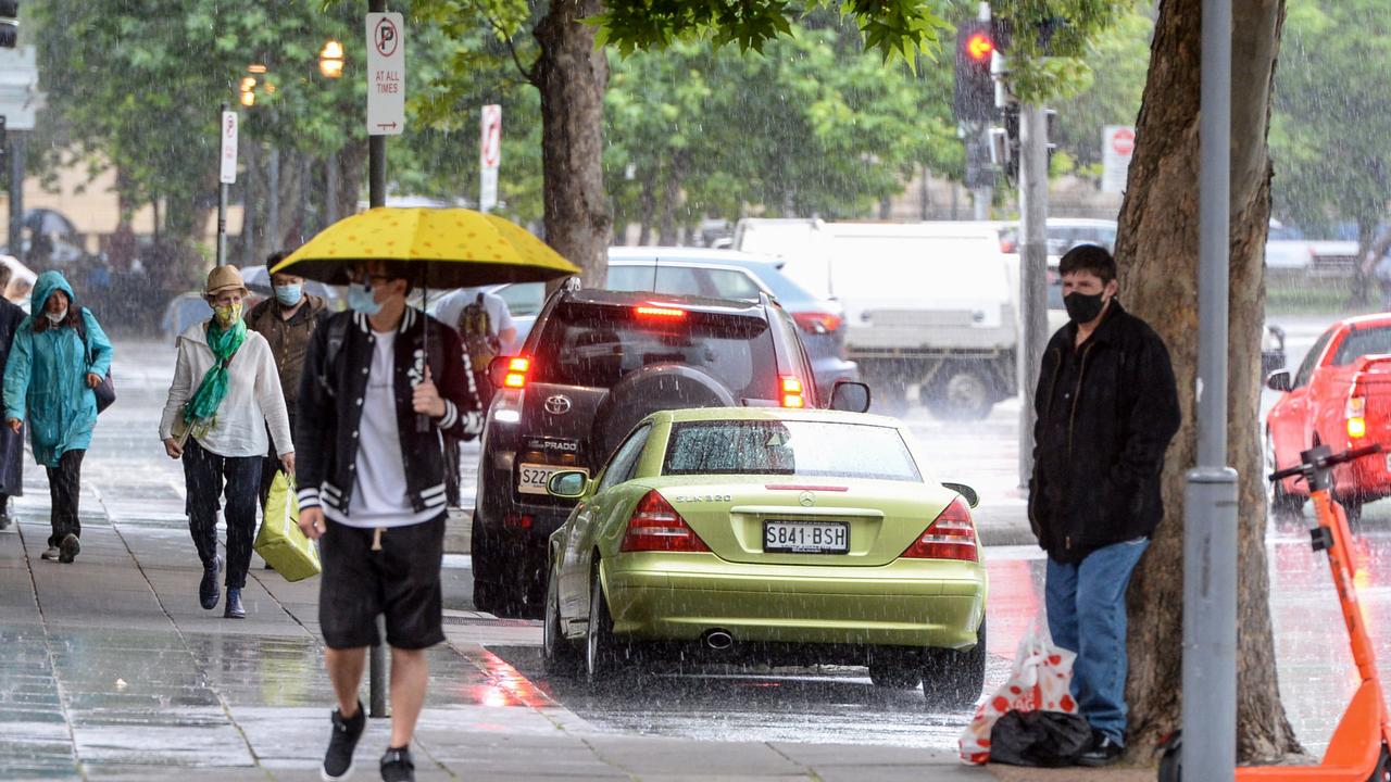 People scurry in the rain as storms lash Adelaide. Picture: NCA NewsWire/Brenton Edwards