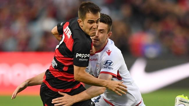 Steven Lustica of the Wanderers (left) is tackled by Adelaide United’s Ben Warland..