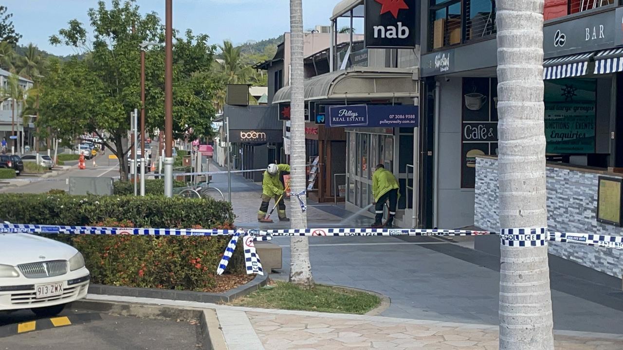 Fire crews clean blood stains from the path where a 24-year-old Western Australia man was shot dead on Airlie Beach's main strip. Picture: Janessa Ekert