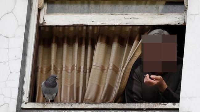 A resident at his window on the top floor of the Gatwick Hotel in Melbourne which is due to close down and be refurbished. Picture: Mal Fairclough