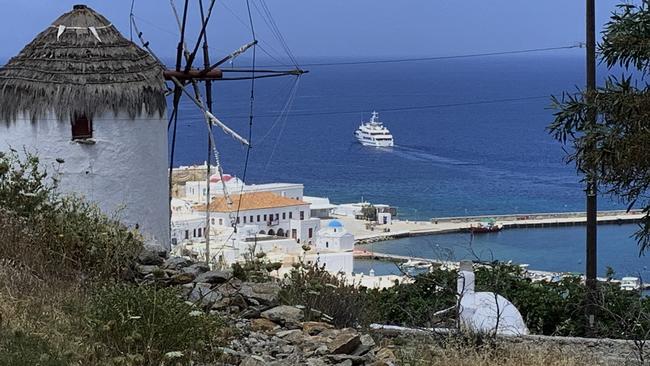 A yacht sails out of the harbor on the Greek island of Mykonos, where tourism operators are keen to reopen.