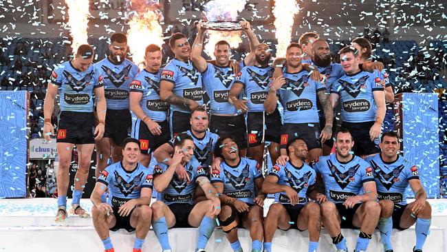 James Tedesco of the Blues holds aloft the Origin trophy and celebrates with team mates after winning the series 2-1 after game three of the 2021 State of Origin Series between the New South Wales Blues and the Queensland Maroons at Cbus Super Stadium.