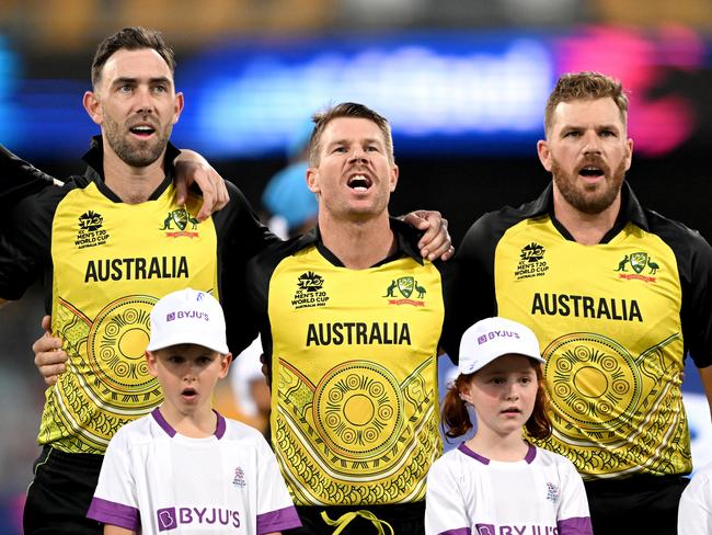 BRISBANE, AUSTRALIA - OCTOBER 31: Glenn Maxwell, David Warner and Aaron Finch of Australia embrace for their national anthem before the ICC Men's T20 World Cup match between Australia and Ireland at The Gabba on October 31, 2022 in Brisbane, Australia. (Photo by Bradley Kanaris/Getty Images)