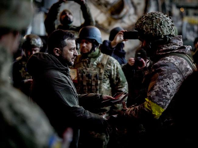 TOPSHOT - In this handout picture taken and released on December 20, 2022 by the Ukrainian Presidential press services Ukraine President Volodymyr Zelensky (L) hands out the State Award to a soldier during a medal giving ceremony to Ukrainian servicemen who have been holding back a fierce and months-long Russian military campaign for the city, as part of Zelensky's visit in the eastern frontline city of Bakhmut, now the epicentre of fighting in Russia's nearly 10-month invasion of Ukraine. (Photo by STRINGER / UKRAINIAN PRESIDENTIAL PRESS SERVICE / AFP) / RESTRICTED TO EDITORIAL USE - MANDATORY CREDIT "AFP PHOTO / UKRAINE PRESIDENCY" - NO MARKETING NO ADVERTISING CAMPAIGNS - DISTRIBUTED AS A SERVICE TO CLIENTS