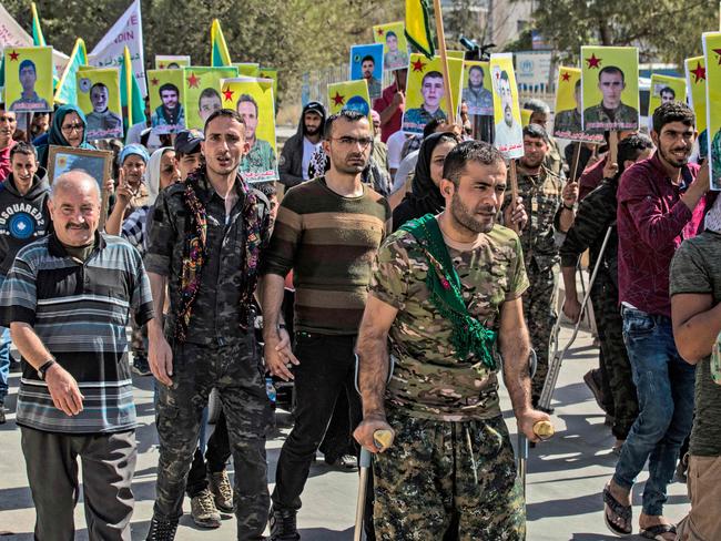 Fighters and veterans from the Kurdish women's protection units (YPJ) and the people's protection units (YPG) march in front of the UN headquarters in the northern Kurdish Syrian city of Qamishli during a protest against Turkish threats in the Kurdish region, on October 8, 2019. - Damascus is ready to welcome Syria's Kurds back into the fold after Washington left them to face Turkish military threats alone, a senior official said in comments published today. Ankara has threatened an offensive in Syria against Kurdish militias it considers terrorists and US forces on Monday pulled back from Turkish border areas, opening the way for an invasion President Recep Tayyip Erdogan has said could come at any moment. (Photo by Delil SOULEIMAN / AFP)