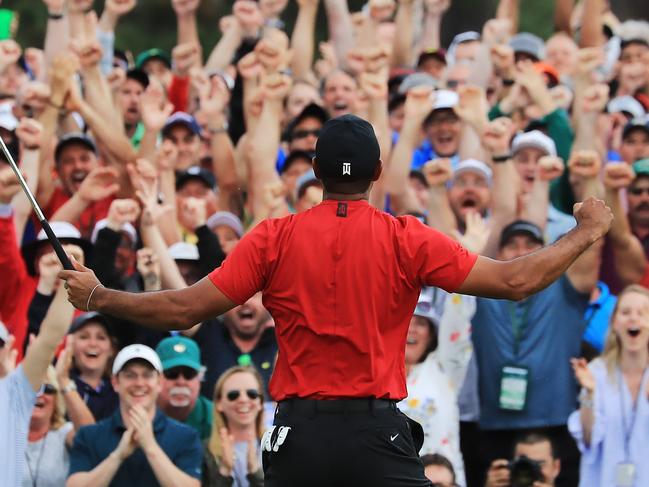 GETTY IMAGES - 2019 Sport Year In Focus - AUGUSTA, GEORGIA - APRIL 14: Patrons cheer as Tiger Woods of the United States celebrates after sinking his putt on the 18th green to win during the final round of the Masters at Augusta National Golf Club on April 14, 2019 in Augusta, Georgia. (Photo by David Cannon/Getty Images)