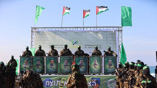 Hamas fighters secure an area before handing over an Israeli-America to a Red Cross team in Gaza City on Saturday. Picture: AFP