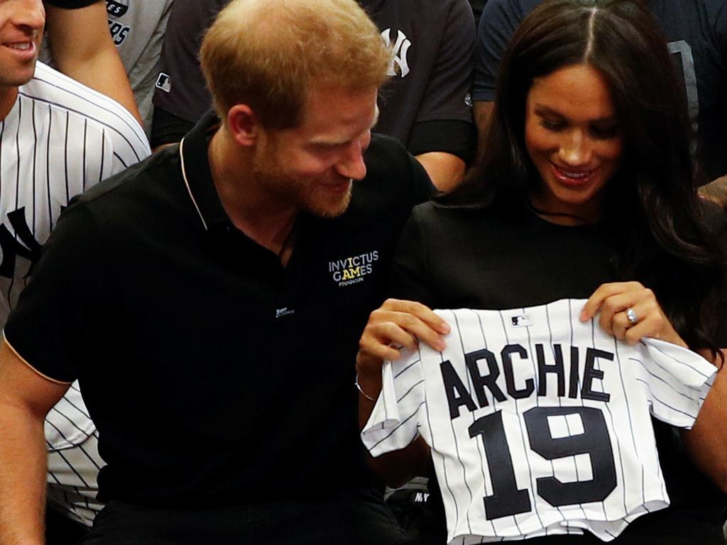 Harry and Meghan with Archie’s new shirt. Picture: Getty