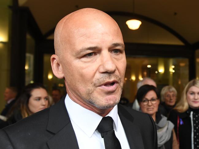 Former NSW Detective Gary Jubelin (left) with supporters including Mark and Faye Leveson (far right), the parents of Matthew Leveson, leaves the Downing Centre Courts in Sydney, Tuesday, July 30, 2019. NSW detective Gary Jubelin, who led the fresh search for three-year-old William Tyrell, is due to face a Sydney court on surveillance charges. (AAP Image/Dean Lewins) NO ARCHIVING