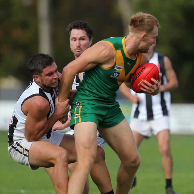 Leongatha’s Will Dawson has one arm pinned in a tackle from Sale opponent Adam Wallace. Picture: Yuri Kouzmin