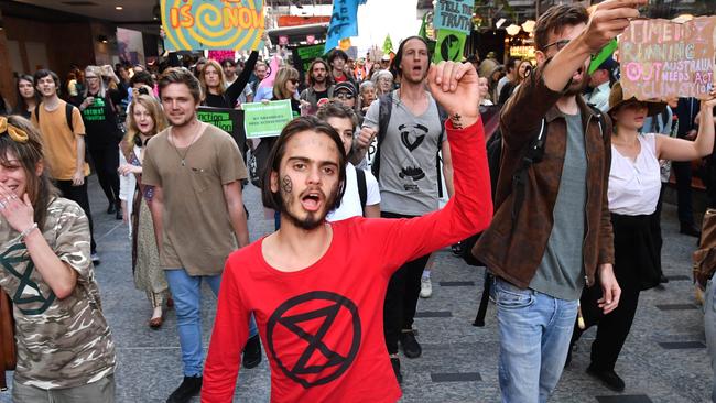 Eric Herbert, centre, and other Extinction Rebellion protesters march down Brisbane’s Queen Street Mall yesterday. Picture: AAP