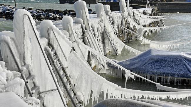 Ice covers the harbor wall and ships on the shore of Lake Constance, in Romanshorn Switzerland, Monday, Feb. 26, 2018.  (Walter Bieri/dpa via AP)