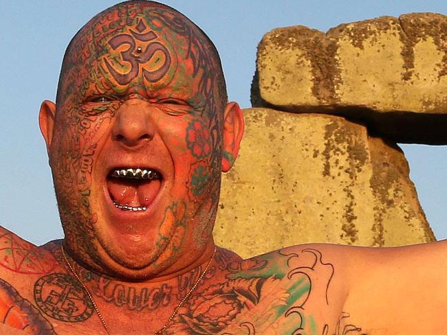 TOPSHOTS A reveler called Mad Alan (real name) celebrates the 2014 summer solstice, the longest day of the year, at sunrise at the prehistoric monument Stonehenge, near Amesbury in Southern England, on June 21, 2014. The festival, which dates back thousands of years, celebrates the longest day of the year when the sun is at its maximum elevation. Modern druids and people gather at the landmark Stonehenge every year to see the sun rise on the first morning of summer. AFP PHOTO / GEOFF CADDICK