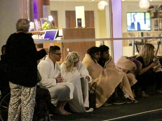 People huddle in the cold after they were evacuated at the Novotel Hotel.