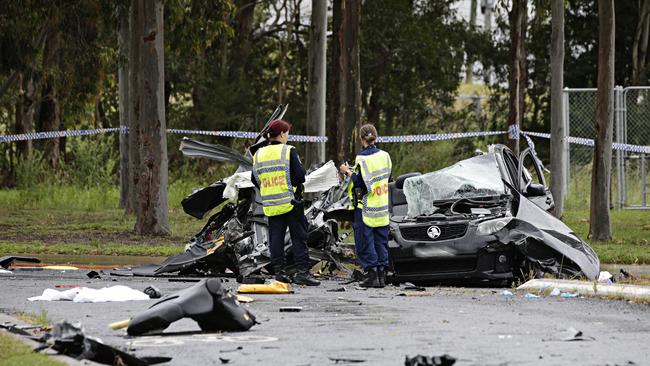 Police look over the crime scene where the fatal car crash occurred Sunday.