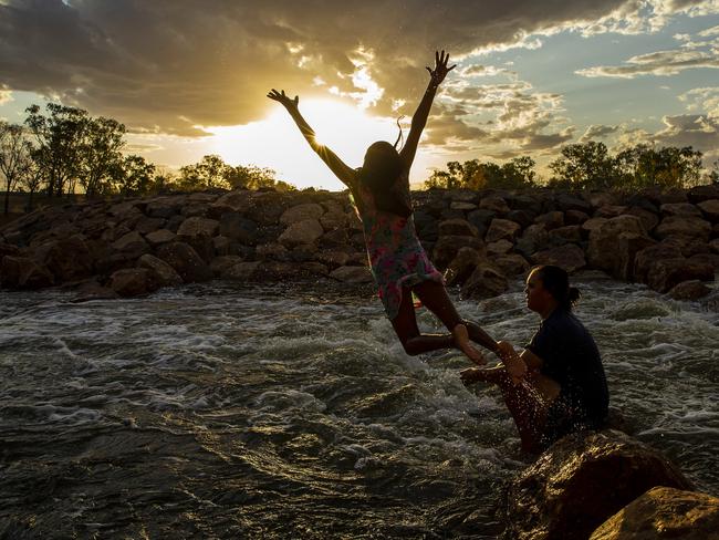 A girl jumps from rocks at Brewarrina Weir after heavy rain last month. Picture: Getty Images