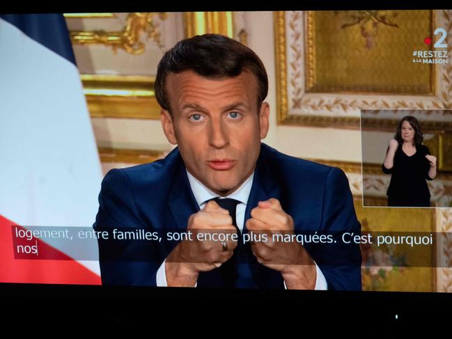 French President Emmanuel Macron is seen on a monitor in Paris, as he spoke to France, extending the country’s lockdown until May 11. Picture: AFP