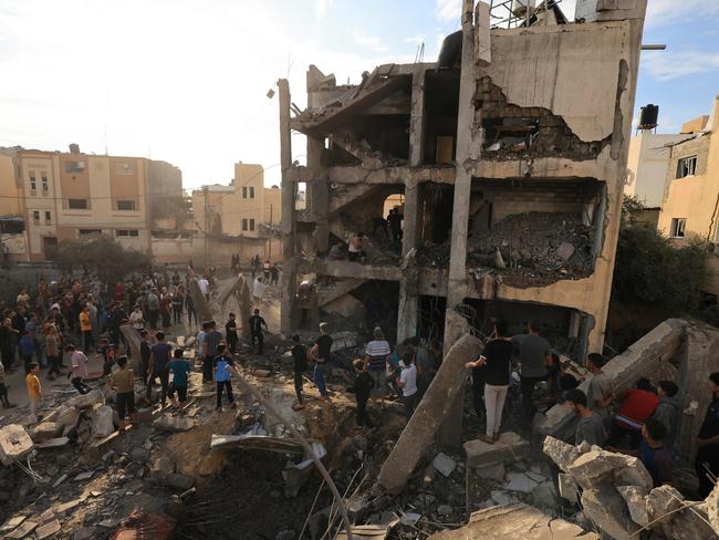 People search through the rubble of a building after an Israeli strike in Khan Yunis. Picture: Mahmud Hams/AFP