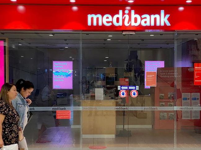 People walk past a shop front for Australia's largest health insurance company Medibank, in Sydney on November 11, 2022. - Russian hackers carried out a cyberattack on Medibank that breached the data of 9.7 million people, including the country's prime minister, police said 11 November. (Photo by Muhammad FAROOQ / AFP)