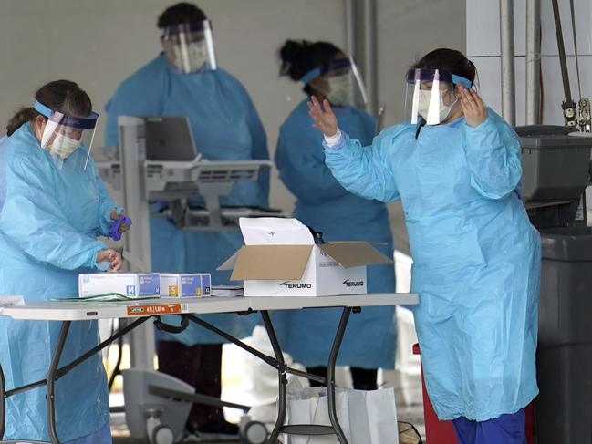 Medical professionals put on new gloves after washing their hands at a newly opened drive-through testing site for COVID-19 Friday, March 20, 2020, in Houston, Texas. Picture: AP