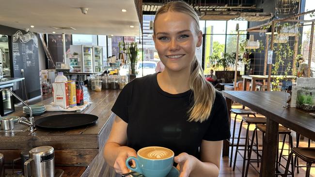 Emjays Birtinya staff member Lily Wooldrage serves a customer a coffee.