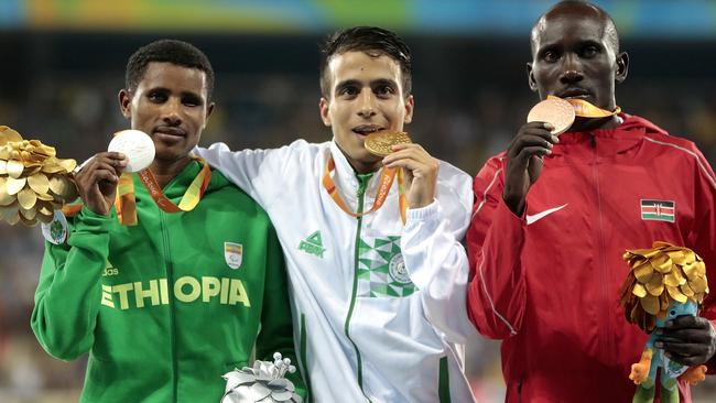 Silver medallist Tamiru Demisse, gold medallist Abdellatif Baka and bronze medallist Henry Kirwa celebrate on the podium at the medal ceremony for the Men's 1500m - T13 (left to right).