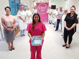 Chair and Co-founder of the Coffs Harbour Pink Silks Perpetual Trust Tanya Johnson (left) and fellow committee member Nicole Pymont (right) with surgeon Shehnarz Salindera (centre) and Perioperative Services team members Kimberley Naylor, Brie Louez, Janice Chew, Kim Batty, Cherie Manuel, Leisl Dowling and Manager Margaret Laidley. Dr Salindera is holding one of the retractors and one of the monitors is at the back with Kim Batty.